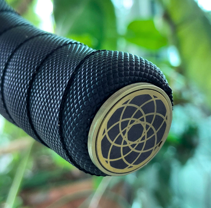 Close-up of a bicycle handlebar with  titanium end cap against a blurred green background