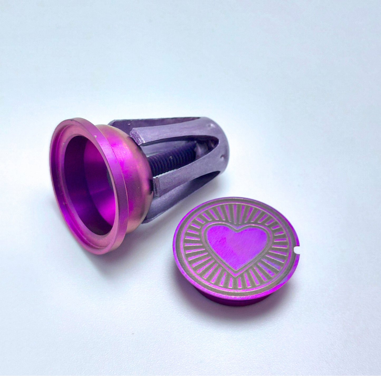 Mybikemonogram.com pink anodized Titanium with heart design on a light blue background