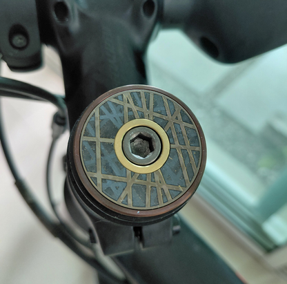 Close-up of bicycle spokes design, titanium Stem top cap, bronze and gold.
