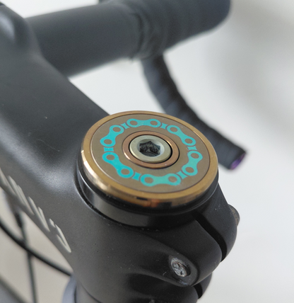Bicycle chain design green and gold titanium Stem top cap mounted on the bike